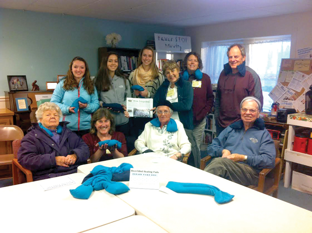 Stow Senior Girl Scout Troop 72526 donated 17 handmade rice-filled heating pads to the seniors at the COA.  Pictured (back row; left to right) are: Margo Coppes, Maria Guerin, Jordan Bricknell, Lisa Dubois (holding the Stow Independent paper), Sharon Funkhouser (COA Outreach Coordinator), Larry Weiss. Front row (l-r):  Gladys McClellan, Alyson Toole (COA Director), Ruth Banfield, & Ralph Banfield. Other troop members who helped make these:  Melissa Buck, Amanda Suleski