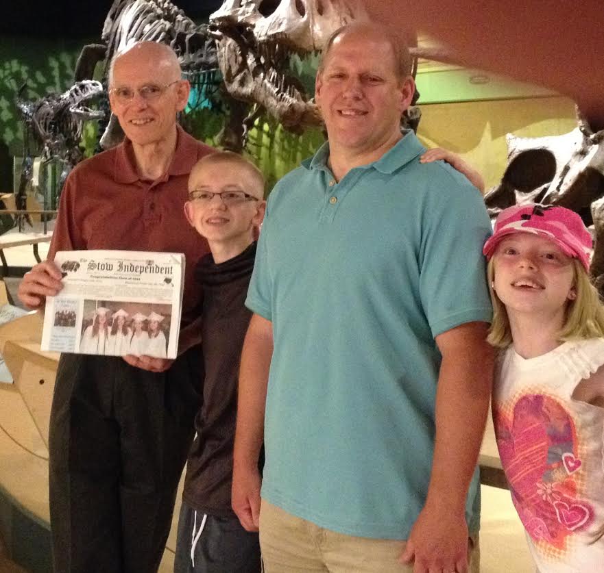 Dave Weber of Stow holding the Stow Independent while visiting the Cleveland Ohio Natural History Museum with nephew Charlie Weber and Charlie's children, Jacob and Lauren