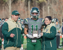 Named Defensive MVP in the Thanksgiving Day game, Egan Bachtell received his award from Coach Jamie Tucker and Athletic Director Tania Rich.             SusanShaye.com